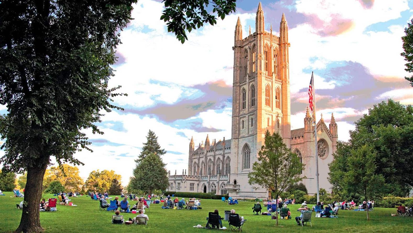 The Trinity College Chapel with students sitting on the grass